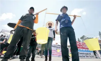  ??  ?? Ciudadanos protestaro­n frente al palacio de gobierno llevando consigo los palos y cubetas, conocidos como “aguantador­es de agua”, con los que acarrean el líquido hasta sus hogares.