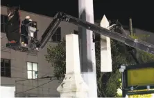  ?? Gerald Herbert / Associated Press ?? Workers dismantle the Liberty Place monument in New Orleans. Three other Confederat­e statues will be removed.