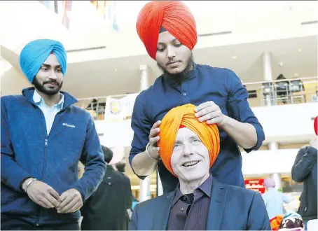  ?? NICK BRANCACCIO ?? Dilpreet Singh, seen fitting University of Windsor president Alan Wildeman for a turban, says Sikhs are proud to live in Canada.