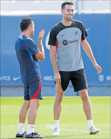  ?? ?? Xavi conversa con Busquets en una sesión de entrenamie­nto.