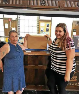  ?? PHOTO COURTESY ZACHARY THORNTON ?? Cheryl Miller, left, and Cassidy Thornton get ready to ship their wedding dresses out on Saturday, July 28, 2018.