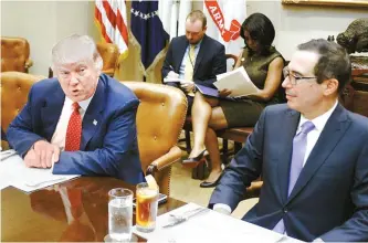  ?? UPI-Yonhap ?? U.S. President Donald Trump discusses the Federal budget as Treasury Secretary Steve Mnuchin, right, looks on with officials over lunch in the Roosevelt Room of the White House in Washington, Wednesday.