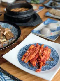  ??  ?? Above: Regional fare—including fiery kimchi—at the family-run Sansumyeon­gsan restaurant. Opposite, from
left: A view over Alpensia from the observatio­n deck of the resort’s ski jump tower; a monk’s shoes outside Woljeongsa Temple.