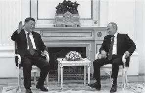  ?? SERGEI KARPUKHIN/SPUTNIK/KREMLIN POOL PHOTO VIA AP ?? Chinese President Xi Jinping chats with Russian President Vladimir Putin on Monday in Moscow.