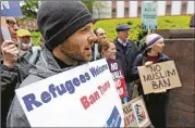  ?? TED S. WARREN / ASSOCIATED PRESS ?? Miles Treakle holds a sign reading “Refugees Welcome Ban Trump” as he protests Monday outside a federal courthouse in Seattle, where arguments in the travel ban case were being heard.