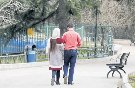  ??  ?? POISON ARROW: A couple walk in a park in Tehran. The mehrieh system has left thousands of men languishin­g in jail and many more destitute.