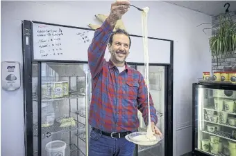  ?? SURESH DOSS FOR THE TORONTO STAR ?? Nablus Creamery’s Anan Zaqa demonstrat­es how elastic nabulsi cheese is when it’s warmed.