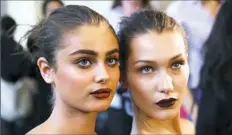 ?? Vittorio Zunino/Getty Images ?? Taylor Marie Hill, left, with Bella Hadid, wears glittering red lipstick backstage for the Atelier Versace fall 2016 runway show. Will any stars be bold enough to try this popular beauty look on the red carpet?