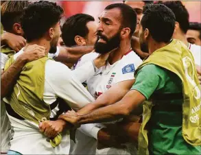  ?? Francisco Seco / Associated Press ?? Iran’s Rouzbeh Cheshmi, center, celebrates scoring against Wales on Friday.