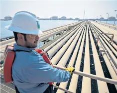  ??  ?? A worker examines pipelines at Saudi Aramco’s Ras Tanura refinery in the Persian Gulf