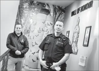  ?? Herald photo by Ian Martens ?? Regimental Sergeant Major Shawn Davis, along with police chaplain Aaron Moore, standing in front of the Wall of Honour, have been part of the Lethbridge Police Service's efforts to honour Calgary police officer Andrew Harnett, who was killed during a traffic stop New Year’s Eve. @IMartensHe­rald