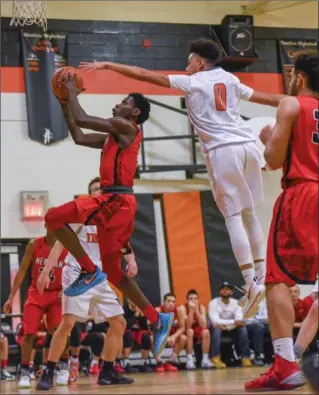  ?? GARY YOKOYAMA, THE HAMILTON SPECTATOR ?? Cardinal Newman’s Maleik Gordon goes up and around a Brantford North Park CVS player during first-day action at the 46th Silver Fox tournament Thursday at Glendale Secondary School. Newman beat North Park, 57-37. Play continues Friday with games at...