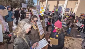  ??  ?? Jean Grehan, left, and Amy Adler sign their names to a petition for U.S. Rep. Ben Ray Luján, who is running for the U.S. Senate, at the Capitol during a Women’s March rally. Tara Lujan, no relation to Ben Ray Luján, was collecting signatures. This year’s event has significan­tly less people than previous years.