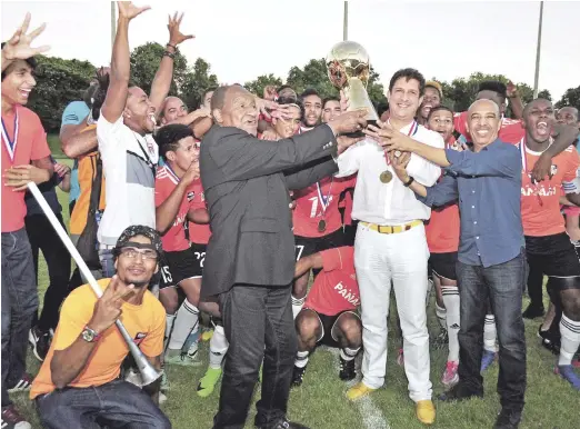  ??  ?? El empresario Manuel Estrella recibe la copa de campeón de manos de Osiris Guzmán y Félix Ledesma.