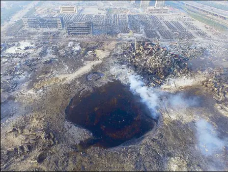  ?? EPA ?? Photo shows a large hole in the ground in the aftermath of a huge explosion that rocked Tianjin in China Friday.