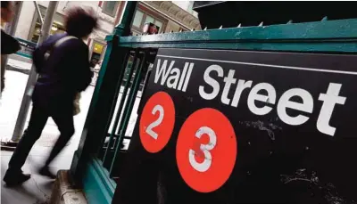  ?? —AP ?? NEW YORK: People pass a Wall Street subway stop in New York’s Financial District. Most world stock indexes fell on Friday while oil prices rose after the US fired missiles at Syria during President Donald Trump’s first meeting with China’s president,...