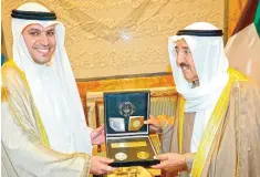  ?? — KUNA ?? KUWAIT: Governor of the Central Bank of Kuwait Dr Mohammad Yousef AlHashel (left) presents HH the Amir Sheikh Sabah Al-Ahmad Al-Jaber AlSabah a set of commemorat­ive coins issued in his honor at Bayan Palace yesterday.
