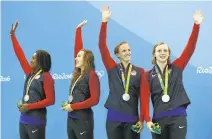  ?? CLIVE ROSE/GETTY IMAGES ?? Silver medalists, from left, Simone Manuel, Abbey Weitzeil, Dana Vollmer and Katie Ledecky of the United States pose during the medal ceremony for the 400 meter freestyle relay.