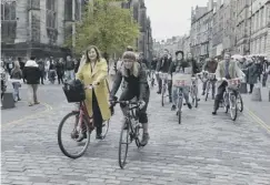  ??  ?? 0 Chloe Wallace, 11, busks on a traffic-free Victoria Street in Edinburgh while pedestrian­s and cyclists alike enjoy safe surroundin­gs