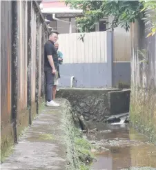  ?? ?? Lam checks a drain in Batu Lintang.