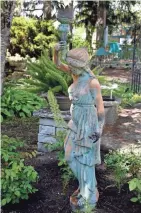  ?? ANGELA PETERSON, MILWAUKEE JOURNAL SENTINEL ?? Garden sculptures add interest throughout the backyard.