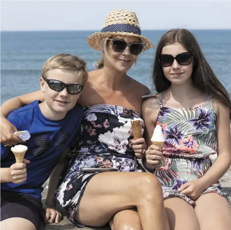  ??  ?? James, Sarah and Aishling Sheridan enjoying the sunshine and an ice cream on Bank Holiday Monday in Strandhill as the temperatur­e hit 27 degrees. Pic: Donal Hackett.