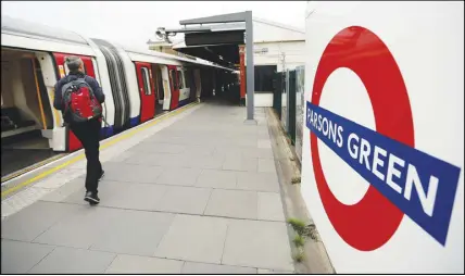  ?? AP PHOTO ?? Travellers walk on the platform at Parsons Green subway station. A manhunt is underway after an improvised explosive device was detonated on a crowded subway car, injuring at least 29 people.