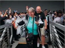  ?? KORI SUZUKI/THE SEATTLE TIMES ?? The first passengers to board Holland America's Westerdam in two years begin walking up the gangplank to the ship as crew members cheer in Seattle on Sunday. The Port of Seattle forecasts that about 265 vessels will sail in 2022, compared to 82 last year.