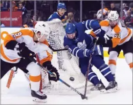  ?? THE ASSOCIATED PRESS FILE ?? Flyers defenseman Ivan Provorov pulls a puck out of trouble in front of Toronto Maple Leafs center Zach Hyman in a game Saturday in Toronto.