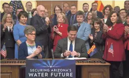  ?? MARK HENLE/THE REPUBLIC ?? Gov. Doug Ducey signs the Drought Contingenc­y Plan on Thursday in the historic Senate Chamber at the Arizona Capitol.