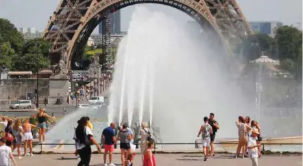  ??  ?? People cool off at the Trocadero Fountains next to the Eiffel Tower in Paris as heatwave scorches Europe.
— AFP file photo