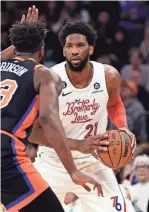  ?? ADAM HUNGER/AP ?? 76ers center Joel Embiid (21) looks to pass around Knicks center Mitchell Robinson during the first half Sunday.