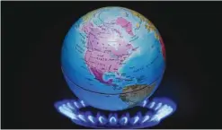  ??  ?? This file illustrati­on photo taken on November 04, 2015 shows a small globe above the flames of a gas ring to illustrate global warming. When the world triumphant­ly celebrated the signing of the landmark Paris climate pact last December, it was hard to...