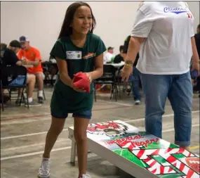  ??  ?? Kianah Alvarez, 9, prepares to make a throw during a match in the fourth annual Cornhole Tournament held at Ricochet in Imperial on Saturday afternoon. VINCENT OSUNA PHOTO