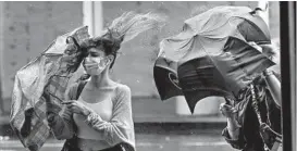  ?? FRANK FRANKLIN II/AP ?? Pedestrian­s in New York struggle with their windswept umbrellas Friday.