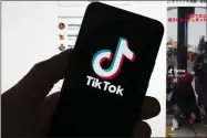 ?? AP PHOTO/MICHAEL DWYER, FILE ?? FILE - The Tiktok logo is seen on a mobile phone in front of a computer screen which displays the Tiktok home screen, Saturday, March 18, 2023, in Boston. Tiktok’s CEO plans to tell Congress that the video-sharing app is committed to user safety, data protection and security, and keeping the platform free from Chinese government influence.