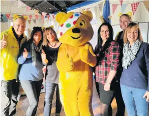  ??  ?? Pudsey Bear, with Roger Johnson, left, visits Home-Start’s weekly Family Group at Canning Road church hall