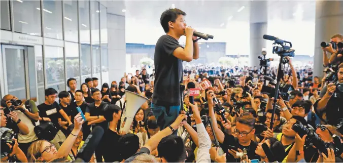  ??  ?? Pro-democracy activist Joshua Wong addresses the crowds outside the Legislativ­e Council in
Hong Kong on Monday.