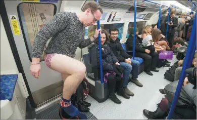  ?? JUSTIN TALLIS / AGENCE FRANCE-PRESSE ?? People take part in the annual “No Trousers On The Tube Day” (also known as the “No Pants Subway Ride”) in central London on Sunday. Started by a New York comedy group in 2002 with only seven participan­ts, the event is now marked in more than 60 cities.