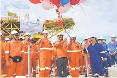  ??  ?? Koh (middle) about to cut the ceremonial ribbon to signify the official completion of the ECP works for the Kinabalu Redevelopm­ent project. Also seen is Repsol’s regional executive director Ferdinando Ricardo (third left)