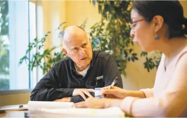  ?? Steve German / Special to The Chronicle ?? Gov. Jerry Brown reviews legislatio­n in his office Sunday with Deputy Legislativ­e Secretary Graciela Castillo-Krings at the state Capitol in Sacramento. On Brown’s final day of bill action, the termed-out governor signed or vetoed 127 bills that had been passed by the Legislatur­e.