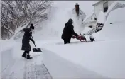  ?? CRAIG RUTTLE — THE ASSOCIATED PRESS ?? Susan Iannuzzi, left, and Linda Marzell of Binghamton, N.Y., clear a sidewalk after a heavy snowfall on a street in Binghamton, N.Y., Thursday.