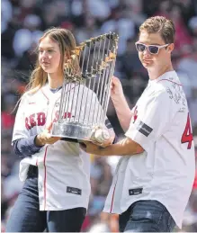  ?? ?? Brianna y Trevor Wakefield, los hijos de Tim y Stacy, fallecidos, sostienen el trofeo de Boston del 2004.
