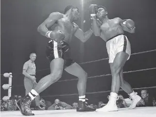  ?? THE ASSOCIATED PRESS/FILES ?? Floyd Patterson, left, delivers a left hook to the chin of Muhammad Ali during their heavyweigh­t title fight, just one of the many thousands of punches to the head Ali took during his boxing career.