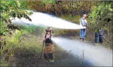  ?? TOM KELLY III — FOR DIGITAL FIRST MEDIA ?? A Norco firefighte­r sprays water on a field and woods fire that broke out in an area between Route 422 bypass and the Schuylkill River Trail in West Pottsgrove Wednesday afternoon. The fire that went to several alarms called in brush pieces and tankers...