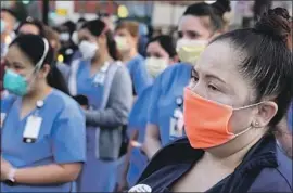  ?? Wally Skalij Los Angeles Times ?? MONIQUE HERNANDEZ, a Riverside nurse, attends a vigil Wednesday outside Hollywood Presbyteri­an Medical Center for a fellow nurse who died of COVID-19.