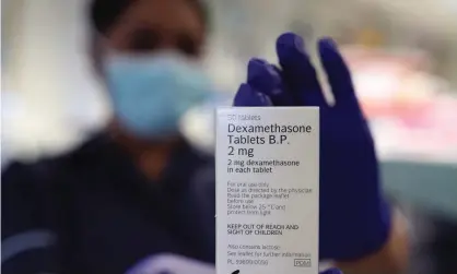  ?? Photograph: Yui Mok/PA ?? A staff member at a pharmacy in London holds a packet of the anti-inflammato­ry drug dexamethas­one, which was hailed as a groundbrea­king treatment for hospital patients seriously ill with Covid-19.