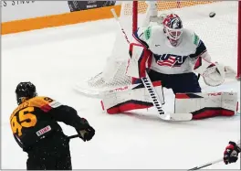  ?? PAVEL GOLOVKIN — ASSOCIATED PRES ?? Germany’s Frederik Tiffels, left, fires off the game-winning shot in overtime Saturday during a semifinal match against the United States at the Ice Hockey World Championsh­ip in Tampere, Finland.