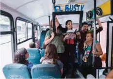  ?? —AFP ?? CARACAS: Laura Castillo (left), Maria Gabriela Fernandez (center) and Dereck Blanco (right) give a presentati­on of Bus TV news on June 6, 2017.