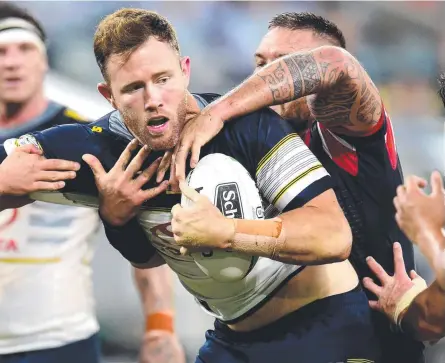  ?? Picture: ALIX SWEENEY ?? UNDER PRESSURE: Cowboys’ backrower Gavin Cooper is wrapped up by the Roosters.